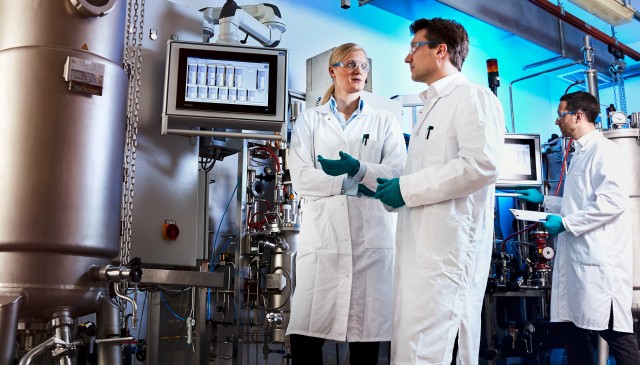 Herstellung von Bio-Anilin: Im kleinen Maßstab klappt der Prozess. Projektleiter Dr. Gernot Jäger (Mitte) arbeitet mit seinem Team (Dr. Swantje Behnken, links, und Dr. Wolf Kloeckner, rechts) daran, ihn auch in größeren Anlagen zu testen.